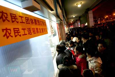 在北京火车站的售票窗口前,购买春运返乡车票的人排起了近百米的长龙。