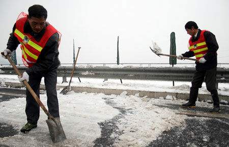 昨日,工作人员正在清理长潭西高速靳江河大桥上的积雪。
