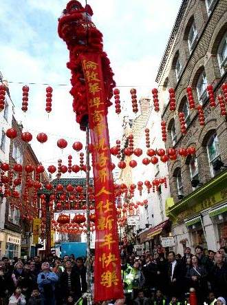 当地时间2月7日(农历年初一)下午,精彩舞狮队在伦敦唐人街大拜年。图为舞狮登高送出祝福“伦敦华埠商会祝各界人士新年快乐”。