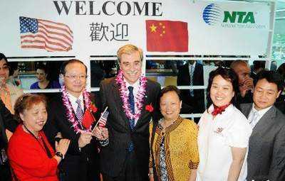 华盛顿时间6月19日晚,美国布什政府内阁成员、商务部长古铁雷斯,和中国国家旅游局局长邵琪伟一同登上波托马克河“奥德赛”号游艇,看望中国首发团240名游客。图为挂着鲜花的古铁雷斯(左三)、邵琪伟(左二),与年龄超过七十岁的游客在船上合影留念。