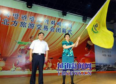 烟台市副市长李淑芹从延边州政府副州长西门顺基手中接过北方旅游交易会会旗