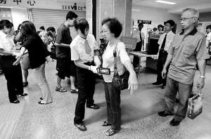 安检人员用手持金属探测仪对乘客的周身检测