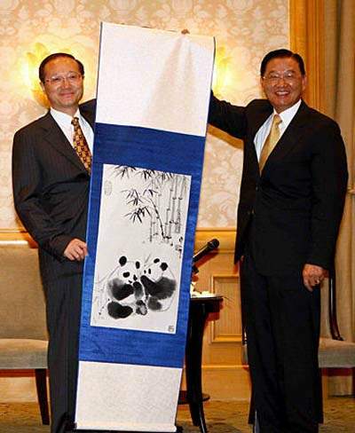 7月10日,海峡两岸旅游交流协会会长邵琪伟(左)向台湾海峡交流基金会董事长江丙坤赠送蜀绣纪念品。 当日,率领大陆居民赴台旅游首发团赴台的海峡两岸旅游交流协会会长邵琪伟,在台北拜会台湾海峡交流基金会董事长江丙坤。