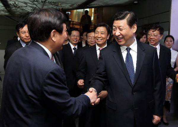 4月29日,前来出席上海世博会开幕式等活动的中共中央政治局常委、中央书记处书记、国家副主席习近平参观上海世博园。这是习近平在中国国家馆参观时与工作人员亲切握手。