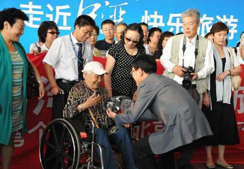 杜江等前往北京首都国际机场为首批赴台个人游游客送行,并赠送台湾游礼品袋